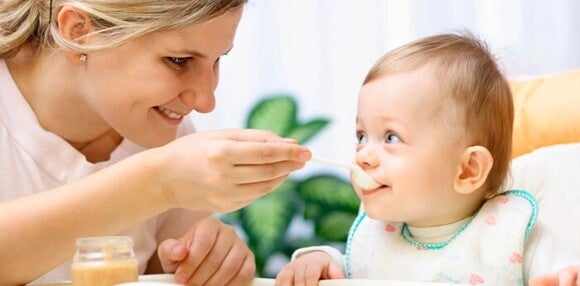 Mamá alimentando a su bebé en su silla